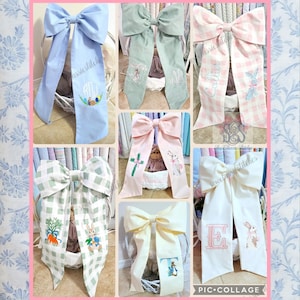 May include: A collage of large fabric bows in various colors, including blue, green, pink, and white. Some bows feature embroidered designs such as Easter eggs, bunnies, and initials. The bows have long, flowing tails.