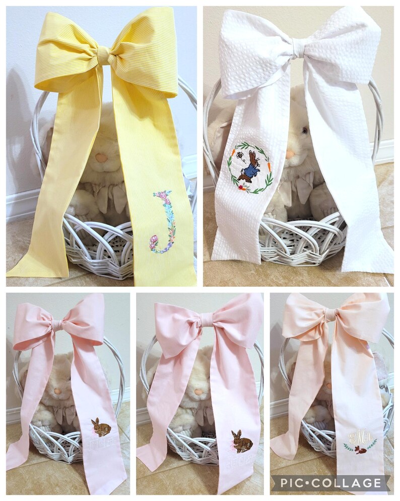 May include: A collage of decorative bows in yellow, white, and pink, each with a long streamer. Some bows have embroidered details like a floral initial, a bunny, or a wreath. The bows are placed in white baskets.