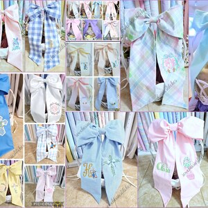 May include: A collage of decorative bows in various colors, including pink, blue, and white. Some bows feature embroidered designs such as crosses, initials, and floral patterns. The bows are likely for gift wrapping or decorative purposes.