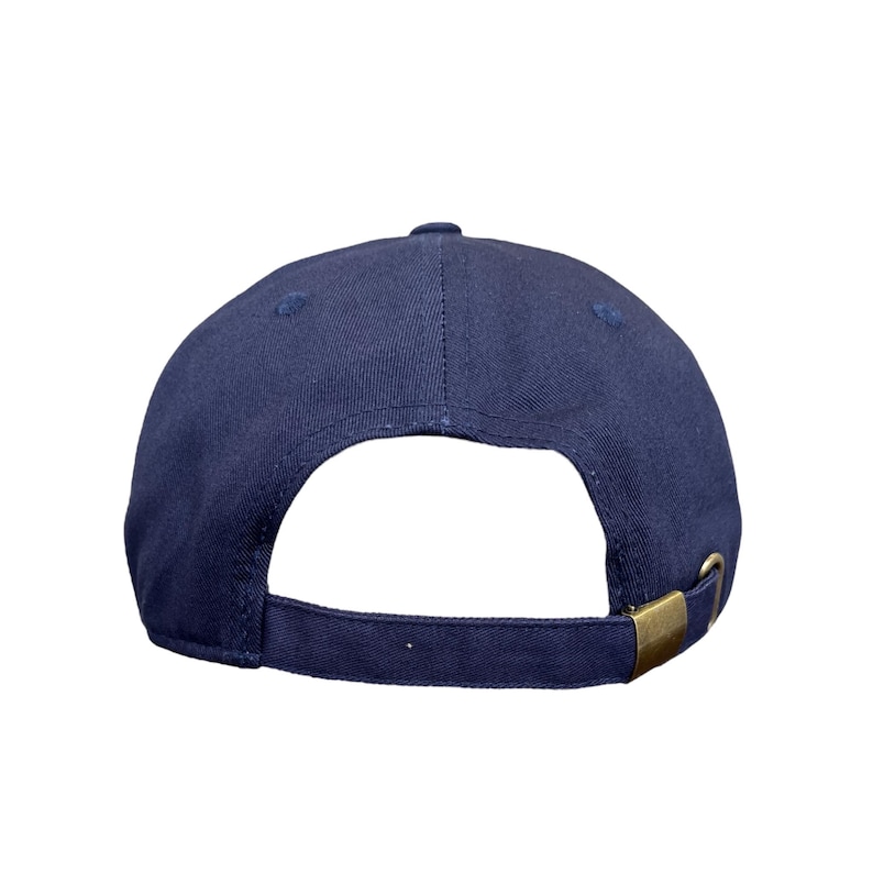 May include: Navy blue baseball cap with a curved brim and adjustable strap. The cap features a brass-colored metal buckle on the back for size adjustment. The cap is made of a durable fabric.