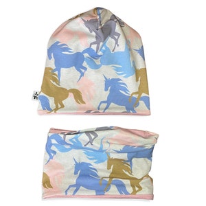 Könnte beinhalten: Ein Set aus zwei Accessoires mit Einhorn-Muster, eine Mütze und ein Halstuch. Beide Artikel haben einen weißen Hintergrund mit einem sich wiederholenden Muster aus blauen, braunen und grauen Einhorn-Silhouetten.