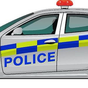 Op de afbeelding: Een witte politieauto met een rood lampje bovenop. De auto heeft een blauw-gele geruite streep aan de zijkant met het woord "POLICE" in blauwe letters.