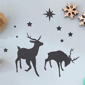 Renne de Noël s'ébattant dans la neige au pochoir pour la fabrication de cartes, la peinture sur tissu, la décoration de gâteaux, la gravure sur verre, les travaux manuels d'art et d'artisanat