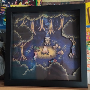 Può includere: Una scena di pixel art incorniciata che rappresenta un gruppo di personaggi riuniti attorno a un falò in un bosco. I personaggi sono pixelati e sembrano provenire da un videogioco. La scena è ambientata su uno sfondo blu scuro con un cielo stellato.