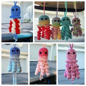 May include: A set of 7 crocheted jellyfish car charms in various colors, including blue, red, pink, green, and yellow. Each charm features a small, round head with black eyes and a long, flowing body with tentacles.