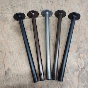May include: Five metal table legs in different finishes: black, bronze, silver, and two shades of black. The legs are round and have a flat base.