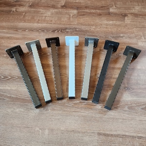 May include: Seven metal table legs in various finishes, including black, white, and brown. The legs are all the same size and shape, with a square top and a rounded bottom.