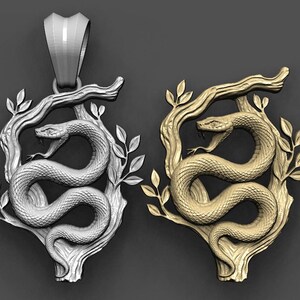 May include: Two pendants featuring a coiled snake with an open mouth, positioned on a textured tree branch with leaves. One pendant is silver-toned and the other is gold-toned. Each piece includes a large, smooth, tapered bail at the top for hanging.