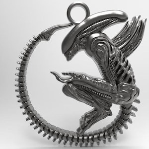Könnte beinhalten: Ein silberner Anhänger mit einer detaillierten außerirdischen Kreatur mit einem eingerollten Schwanz, der an den Xenomorph aus der Alien-Franchise erinnert.