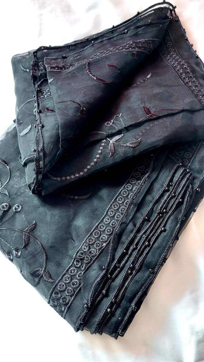 May include: Black sheer scarf with black embroidery and beaded trim.