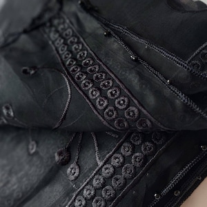 May include: Black sheer scarf with black embroidery and beaded trim.
