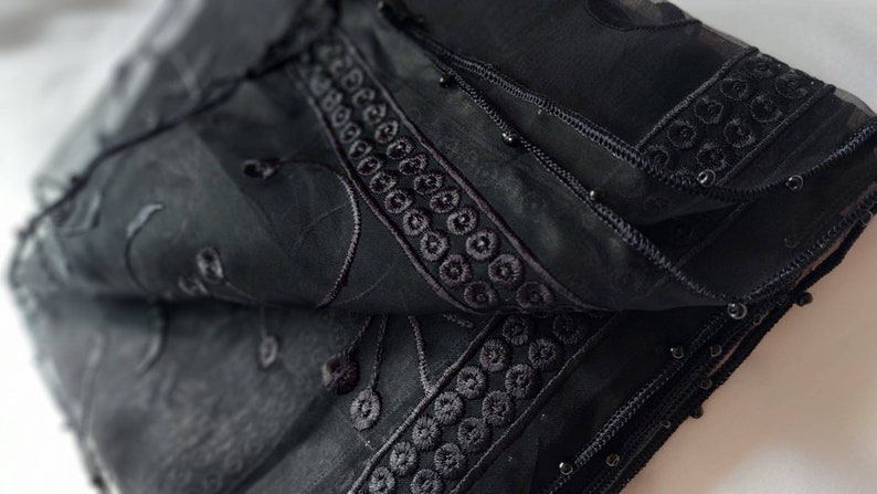 May include: Black sheer scarf with black embroidery and beaded trim.