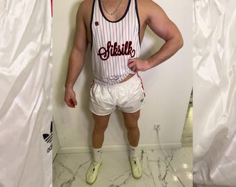 May include: White athletic shorts and a striped tank top with the word "Siksilk" in red script. The tank top has red and blue vertical stripes. The shorts have red stripes along the sides and the Adidas logo.
