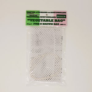 Può includere: Sacchetto per verdure in rete bianca con chiusura a coulisse. Il sacchetto è confezionato in un sacchetto di plastica trasparente con un'etichetta che recita "Realizzato e confezionato a Terranova" e "Sacchetto per verdure".