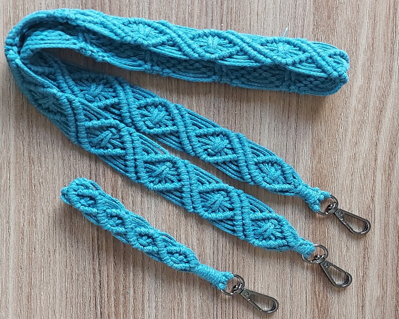 May include: A turquoise blue macrame strap with two silver clasps. The strap is made of a thick, woven cord and has a diamond pattern.