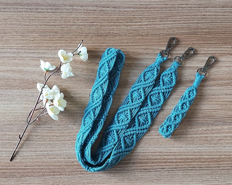 May include: Three teal blue macrame straps with silver metal clasps. The straps are made with a diamond pattern and are different lengths.