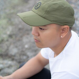 army green cap hat travel hiking commuting running walking techwear gorpcore streetwear water resistant dwr stretchy versal concepts  side model reflective breathable buckle adjustable soft foldable