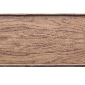 May include: A long, rectangular wooden tray with black metal end pieces. The tray has a natural wood finish and a smooth surface.