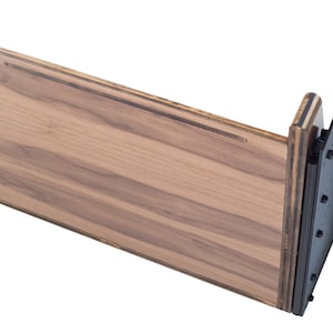 May include: A wooden shelf bracket with a black metal support. The shelf is made of wood with a natural finish. The metal support is attached to the shelf with screws.