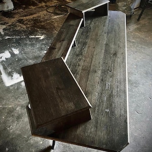 May include: A dark wood desk with three shelves. The desk has a rustic finish and is supported by black metal legs.