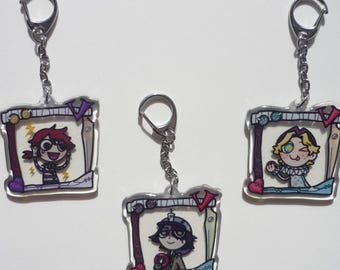 May include: Three acrylic keychains with cartoon character illustrations. Each keychain features a different character within a decorative frame, attached to a silver chain and keyring. The characters have distinct hairstyles and outfits, with vibrant colors.
