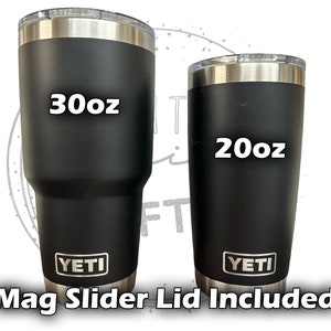 Op de afbeelding: Twee zwarte YETI tumblers met roestvrijstalen deksels. De grotere tumbler is 30 oz en de kleinere tumbler is 20 oz. Beide tumblers worden geleverd met een magnetische schuifdeksel.