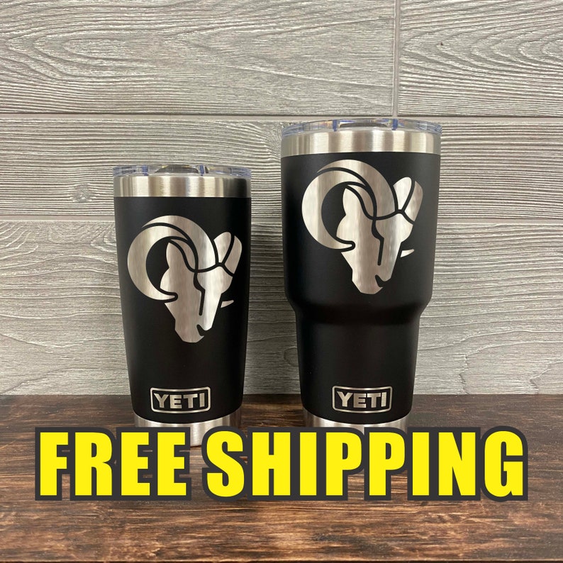 Op de afbeelding: Twee zwarte Yeti-bekers met een zilveren rammenkopontwerp. De kleinere beker is 20 oz en de grotere beker is 30 oz. Beide bekers hebben het Yeti-logo op de bodem.