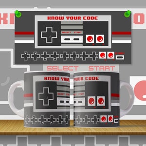 Könnte beinhalten: Zwei weiße Keramikbecher mit einem schwarzen und grauen Design eines Videospiel-Controllers. Die Becher haben den Text "KNOW YOUR CODE" aufgedruckt. Die Becher stehen auf einem Holzregal.