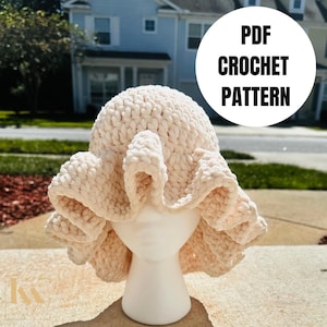 May include: A crocheted hat with a ruffled brim in a cream color. The hat is displayed on a white mannequin head. The text "PDF CROCHET PATTERN" is visible in the image.