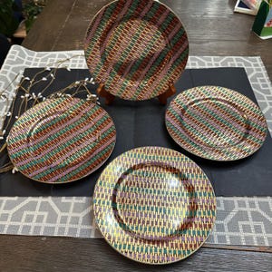 May include: A set of three ceramic mugs with a speckled, matte finish. The mugs are in shades of cream, light gray, and dark gray. Each mug has a simple, minimalist design, perfect for coffee or tea.