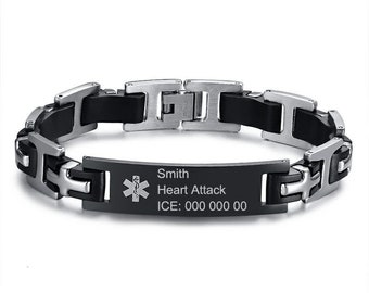 Op de afbeelding: Zwart en zilveren medische armband met een zwart rubberen bandje. De armband heeft een metalen plaat met de tekst "Smith Heart Attack ICE: 000 000 00".