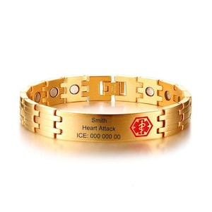 Könnte beinhalten: Goldfarbenes medizinisches ID-Armband mit rechteckiger Platte und Kettenglied-Design. Die Platte trägt den Namen "Smith", die Erkrankung "Heart Attack" und eine Notrufnummer. Ein rotes Medizinsymbol ist ebenfalls vorhanden.