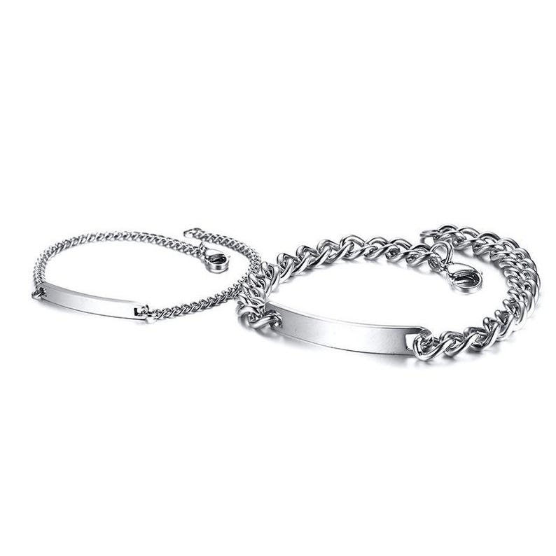 May include: Two silver-toned metal bracelets featuring polished rectangular identification plates. The smaller bracelet has a delicate chain, while the larger bracelet consists of thicker, interlocking curb links. Both pieces include a lobster claw clasp.