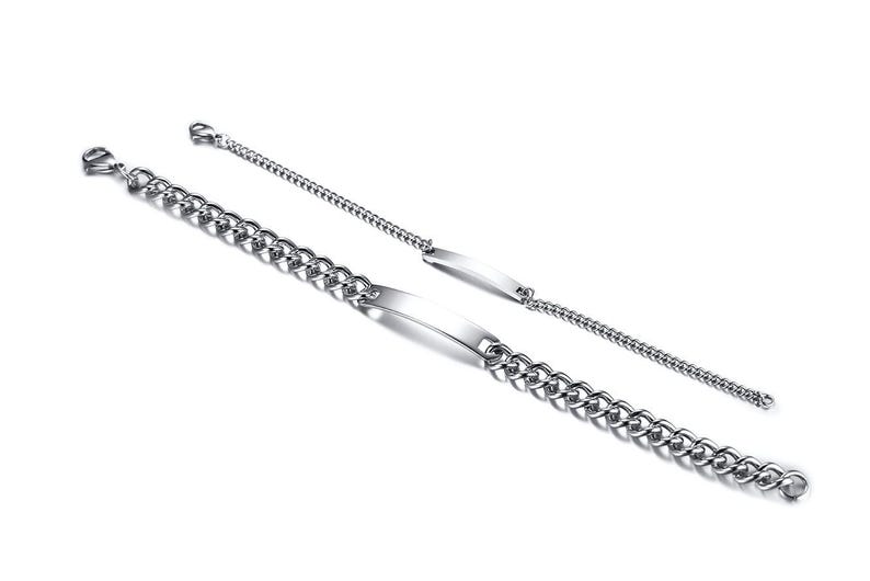 May include: Two silver-toned metal bracelets featuring a polished ID plate at the center. One bracelet has a thick, chunky curb chain, while the other features a thinner, delicate chain. Both bracelets include a lobster claw clasp closure.