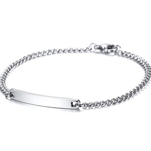 May include: A silver-toned metal chain bracelet featuring a smooth, rectangular identification bar at the center. The bracelet is constructed with small, interlocking links and includes a secure lobster claw clasp closure at the back.
