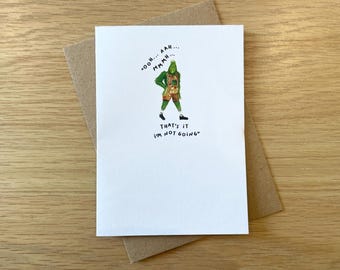 May include: A white greeting card with a cartoon illustration of a green character in a costume. The card has the text "That's it I'm not going" and other phrases. The card is on a brown envelope.