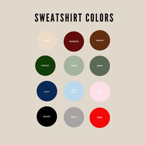 May include: A chart showing 12 different sweatshirt colors, including beige, maroon, brown, forest green, sage green, army green, navy blue, light blue, light pink, black, gray, and red.
