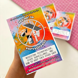 May include: A stack of vibrant cards featuring the phrase "say no! to surveillance" and a graphic of crossed-out surveillance tools. The cards also include text about resisting technofascism and staying safe.