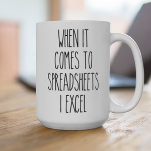 May include: White ceramic coffee mug with black text that reads "When it comes to spreadsheets I excel".
