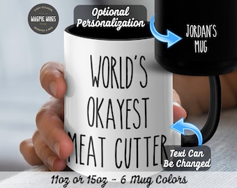 Puede incluir: Taza de cerámica blanca con texto negro que dice "WORLD'S OKAYEST MEAT CUTTER". La taza es de 11 oz o 15 oz y viene en 6 colores. El texto se puede personalizar.
