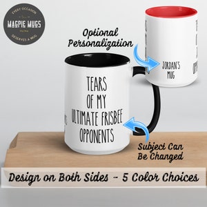 May include: White ceramic coffee mug with a black rim and handle. The mug has black text that reads "Tears of my ultimate frisbee opponents".