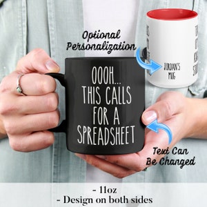 May include: Black 11oz coffee mug with white text that reads "OOOH... THIS CALLS FOR A SPREADSHEET". The mug has a red interior and a white handle. The text "JORDAN'S MUG" is visible on the side of the mug. The text "Text Can Be Changed" is written below the mug.