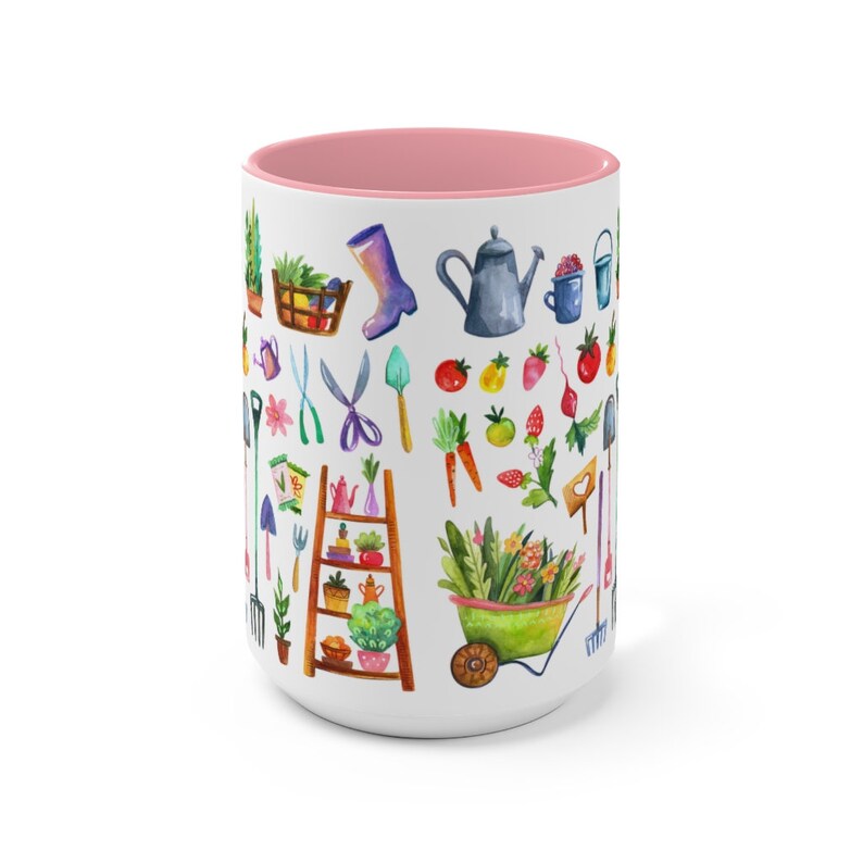 May include: White ceramic mug with a pink interior, decorated with watercolor illustrations of gardening tools, plants, and produce. The design includes a watering can, boots, and a wheelbarrow. A perfect gift for gardeners.