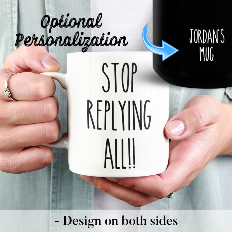 May include: White ceramic mug with the text "STOP REPLYING ALL!!" in black. The mug also features the text "JORDAN'S MUG" on the black side. The design is on both sides. The mug is held by a person.