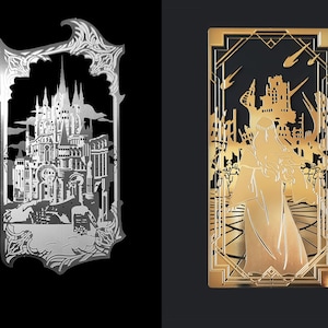 May include: Two metal cutouts, one silver and one gold, depicting a castle and a figure in a robe, respectively. Both cutouts have a decorative frame.