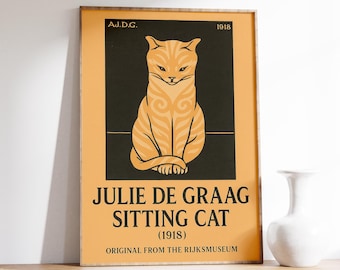Könnte beinhalten: Gerahmtes Poster mit einer stilisierten orangefarbenen Katzenillustration auf schwarzem und orangefarbenem Hintergrund. Der Text "JULIE DE GRAAG SITTING CAT (1918) ORIGINAL FROM THE RIJKSMUSEUM" ist zu sehen. Das Kunstwerk steht auf einem Holzregal.