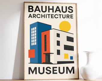 Op de afbeelding: Ingelijste Bauhaus Architecture Museum poster. De print toont een geometrisch ontwerp van een gebouw met blauwe, oranje en witte secties, een gele zon en de woorden "Bauhaus Architecture Museum" in het zwart.