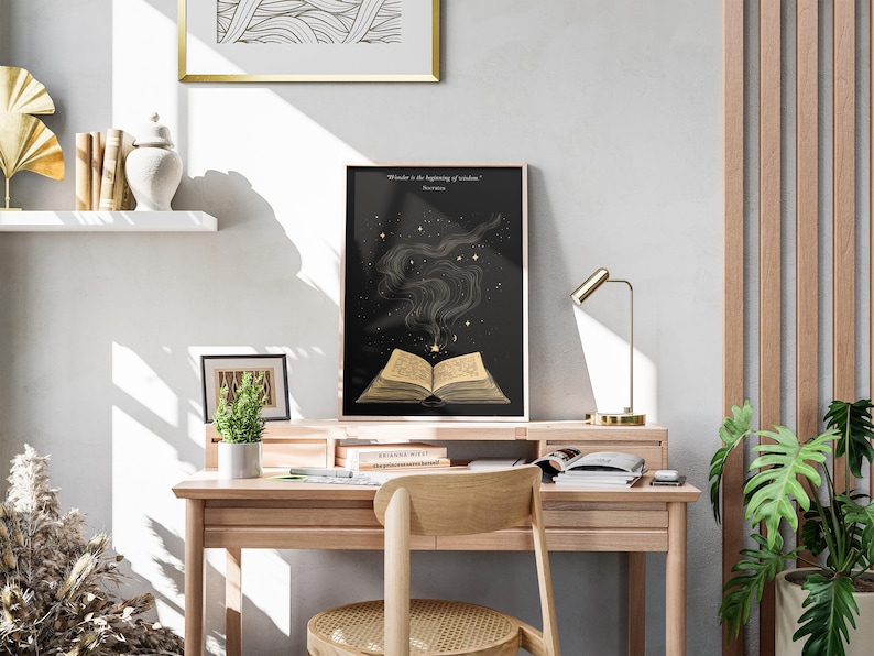 May include: A black and gold poster with a quote about wonder being the beginning of wisdom. The poster features an open book with golden pages and a swirling smoke design with stars.