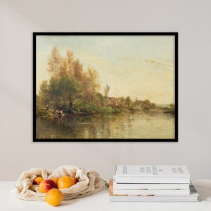 Pode incluir: Uma pintura emoldurada que representa uma cena de paisagem com um rio, árvores e uma pequena aldeia ao longe. A pintura é de estilo rústico com cores suaves.