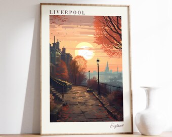 May include: Framed art print of a Liverpool street scene at sunset. The print features a cobblestone path leading towards the sun, with buildings and trees in autumnal colors. The word "Liverpool" is printed at the top, with "England" at the bottom.